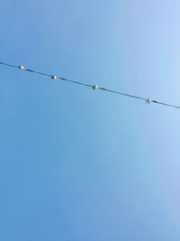 Low angle view of power cable against clear sky