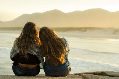 Rear view of women overlooking calm lake