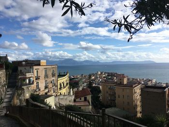 High angle view of townscape by sea against sky