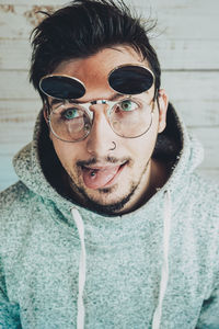 Man wearing sunglasses against wall