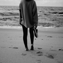 Rear view of man and woman walking on beach