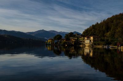 Scenic view of lake by buildings against sky