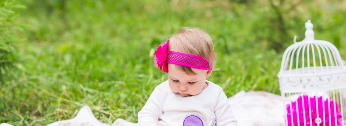 Cute boy looking away while sitting on grass