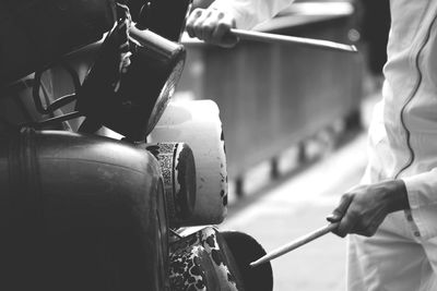 Midsection of street musician playing music from cooking utensils