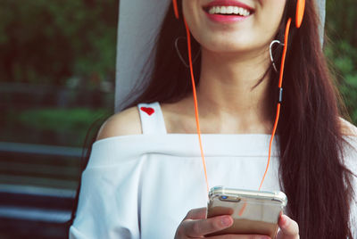 Portrait of a smiling young woman using smart phone