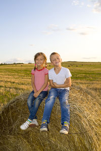 Full length portrait of smiling girl on field