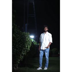 Full length portrait of young man standing outdoors at night