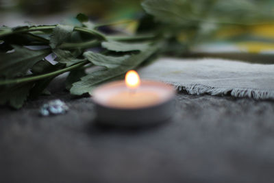 Close-up of lit candle on table