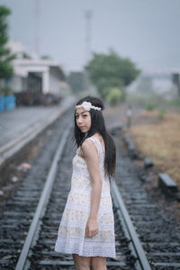 Portrait of woman standing on railroad track