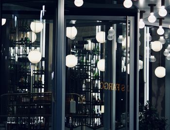 Illuminated lights hanging from ceiling at restaurant