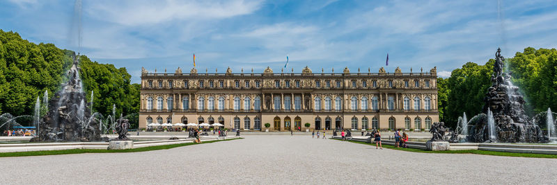 Panoramic view of building in city against cloudy sky