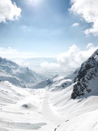 Scenic view of snow covered mountain against cloudy sky