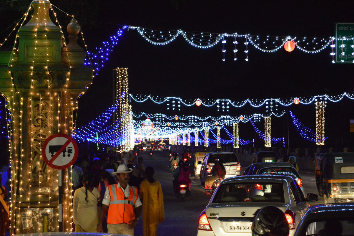 PEOPLE ON ILLUMINATED CHRISTMAS LIGHTS AT NIGHT