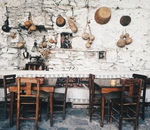 Empty chairs and table against wall