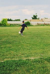 Boy playing with ball on field