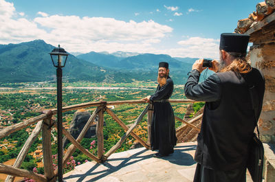 Rear view of people photographing on mountain