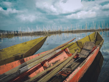 Panoramic view of boats moored at beach against sky