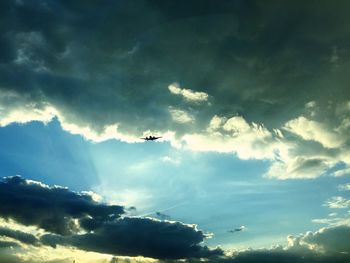 Low angle view of silhouette airplane flying in sky