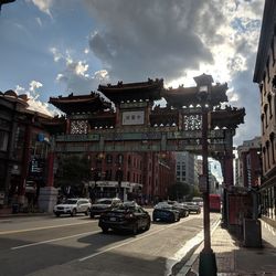 Cars on street amidst buildings in city against sky