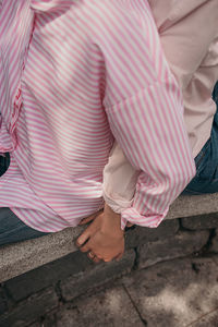 Low section of woman with pink umbrella