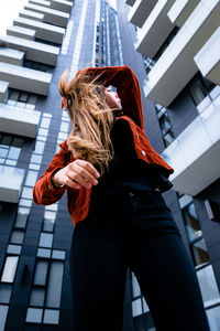 Low angle view of woman standing against built structure