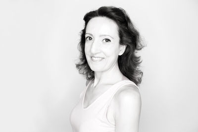 Portrait of smiling young woman against white background