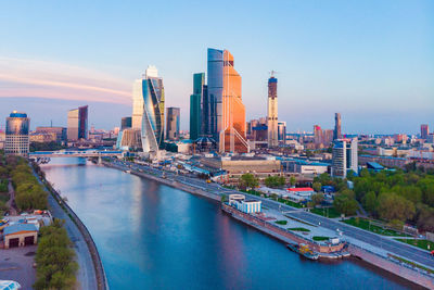 River amidst buildings in city against sky