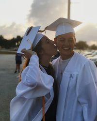 Lesbian woman kissing girlfriend on cheek during sunset