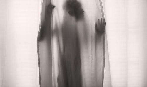 Defocused image of woman standing by window