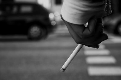 Close-up of hand holding cigarette