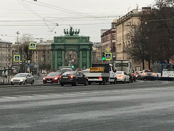 Traffic on road by buildings in city