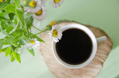 Directly above shot of coffee by flowers in vase on table