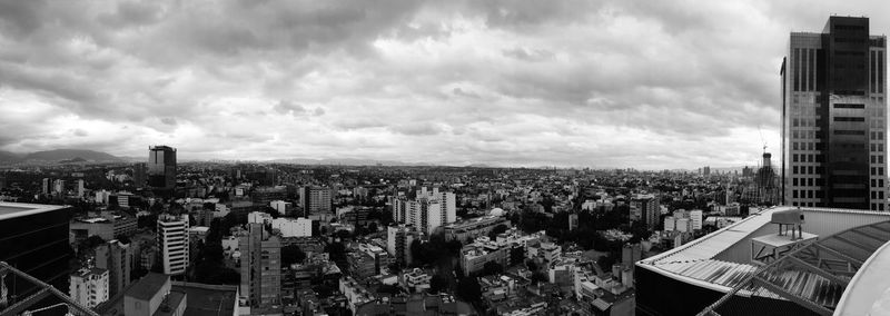 View of cityscape against cloudy sky