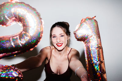 Young woman celebrating her 21st birthday illuminated with hard flash light.