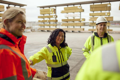 Multiracial female colleagues in protective workwear standing at factory