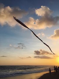 Silhouette man on beach against sky during sunset