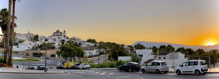 Cars on road against sky during sunset