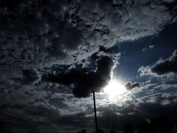 Low angle view of silhouette trees against dramatic sky