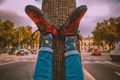 Person standing on street in city against blue sky