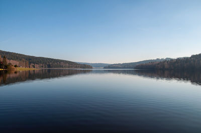 Scenic view of lake against clear blue sky