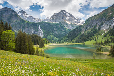 Scenic view of lake by mountains against sky