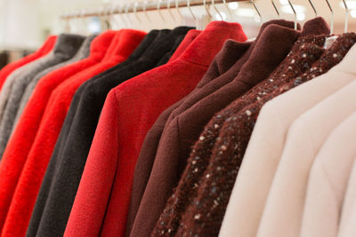 Close-up of multi colored clothes hanging in rack for sale