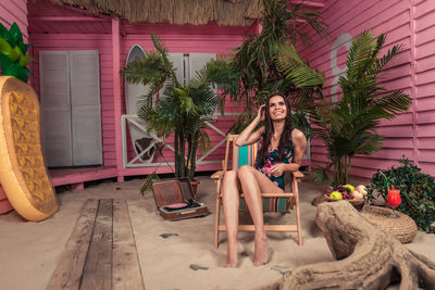 Portrait of woman sitting on potted plant