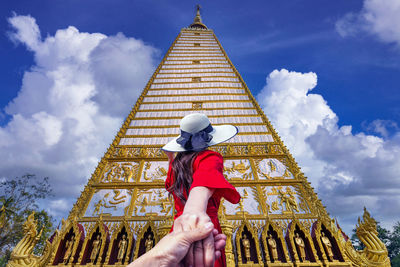 Low angle view of woman standing against sky