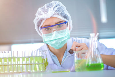 Portrait of scientist adding sample to petri dish with pipette