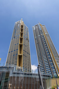 Low angle view of modern buildings against clear blue sky