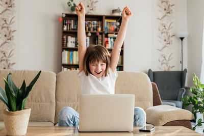 Online distance learning for children at home. the girl sits on the couch in front of a laptop 