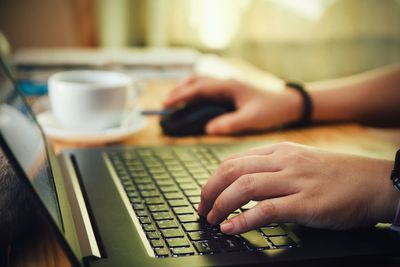 Midsection of man using laptop on table