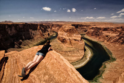 Rear view of woman on rock formation against sky