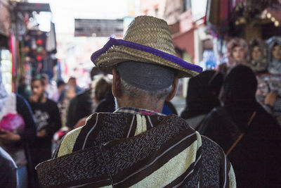 Rear view of man in hat on street 